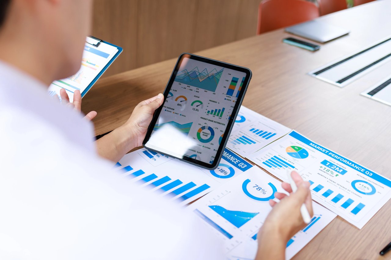 Sales manager reviewing a call analytics dashboard with a sales representative, using performance data to coach with curiosity and identify workflow obstacles instead of assigning blame.