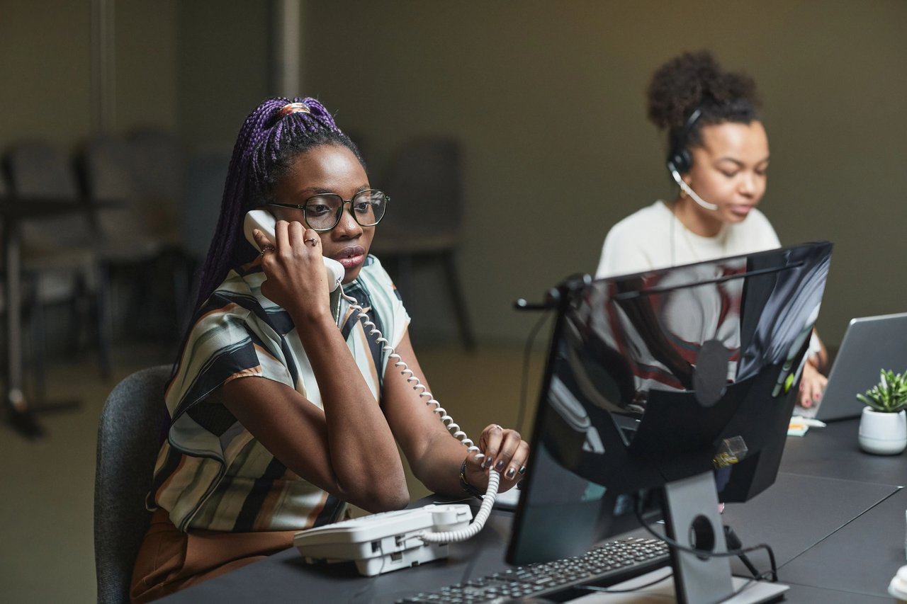 Insurance sales agent engaged in a meaningful phone conversation with a prospective customer while reviewing policy information, illustrating the difference between making calls and conducting effective sales conversations.