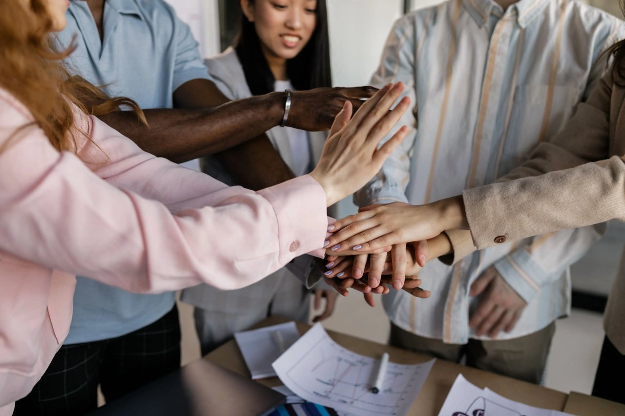 A photo of a small team gathering together to show commitment.