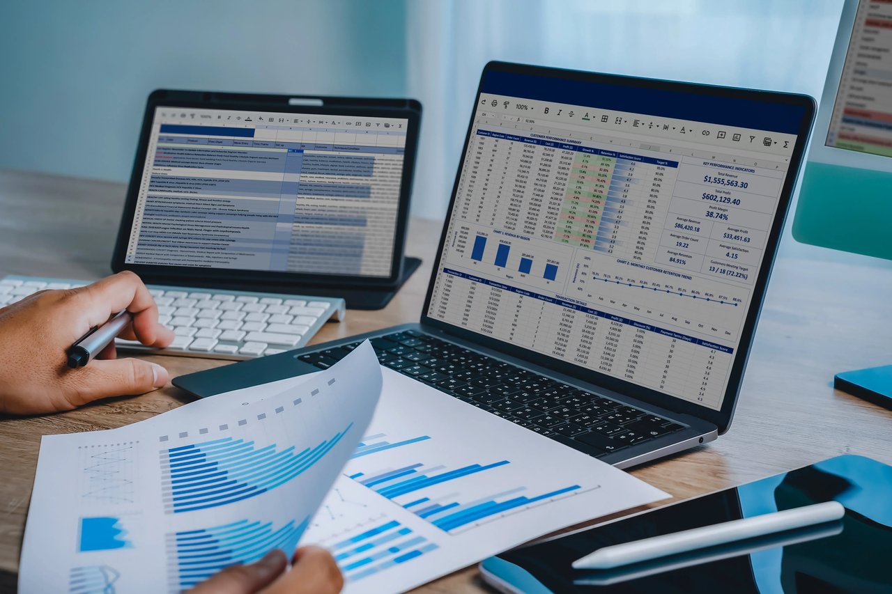 Business professional comparing an Excel spreadsheet with a real-time analytics dashboard, illustrating the limitations of static reports and the value of real-time visibility.