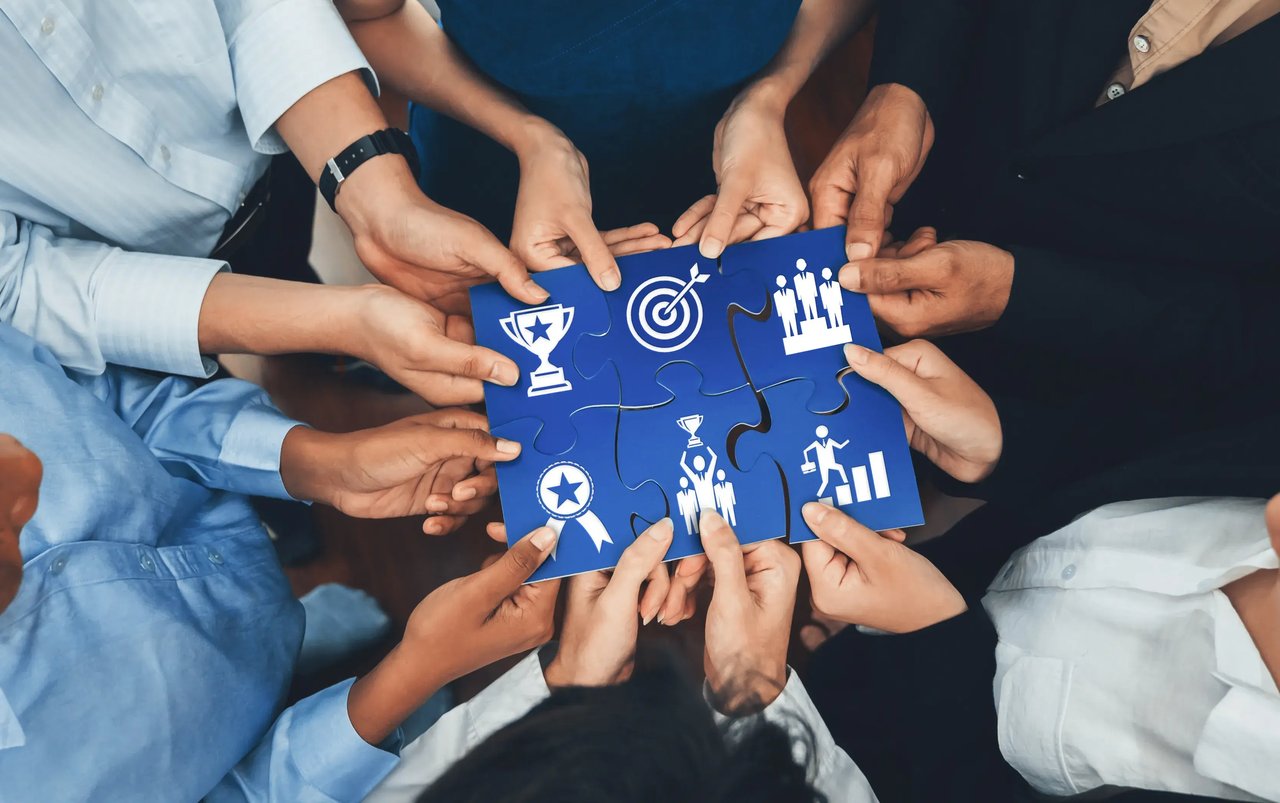 Business strategy concept showing different team members working with shared resources and comparable performance goals.